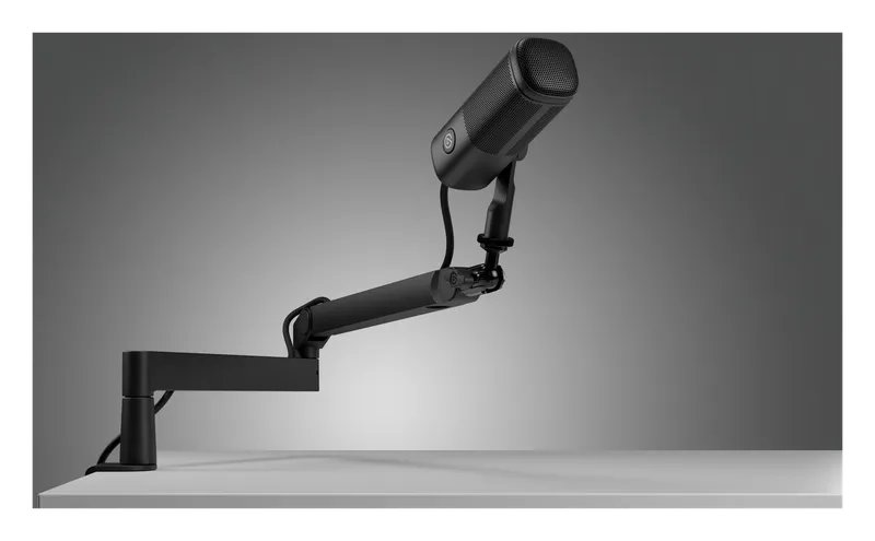 Elgato Wave Mic Arm LP holding a microphone low in front of a monitor