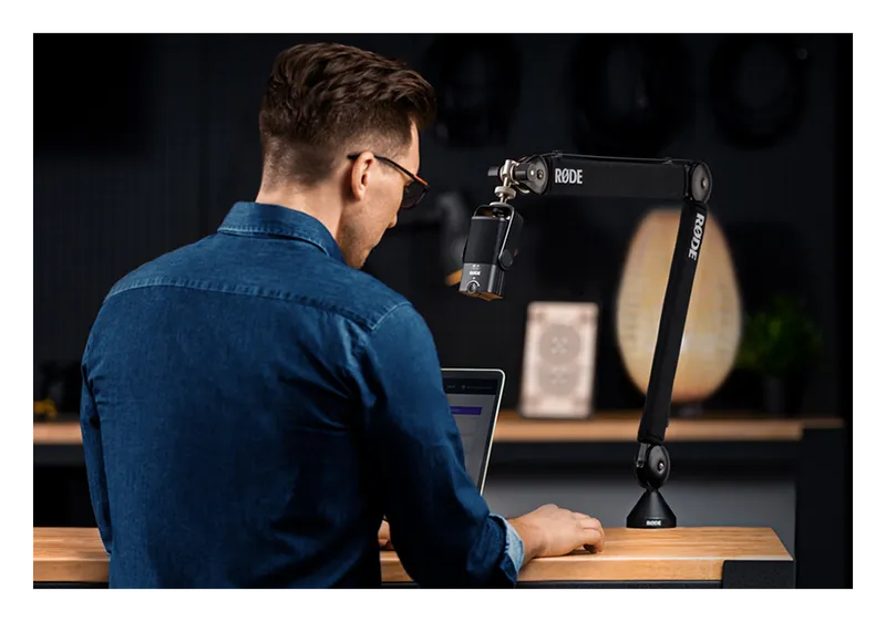 Podcaster speaking into a microphone on a RØDE PSA1+ boom arm