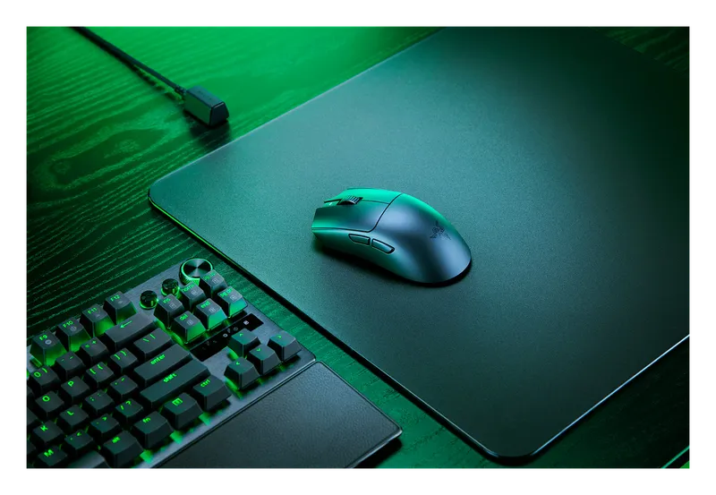 Razer Viper V3 Pro mouse on a mousepad beside a green-lit keyboard