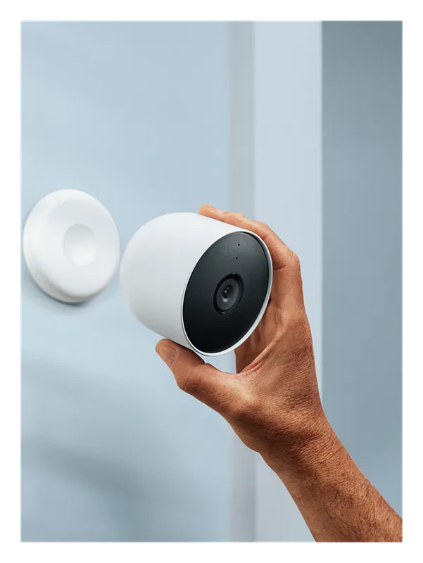 Hand attaching the Google Nest Cam (Battery) to its magnetic mount