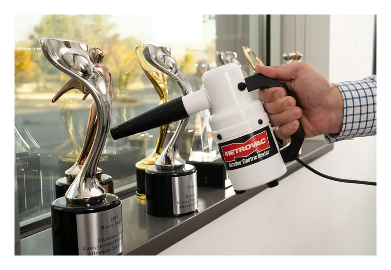 Metro DataVac electric duster blowing dust off trophies