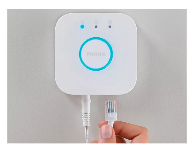 Philips Hue Bridge with an Ethernet cable being plugged in